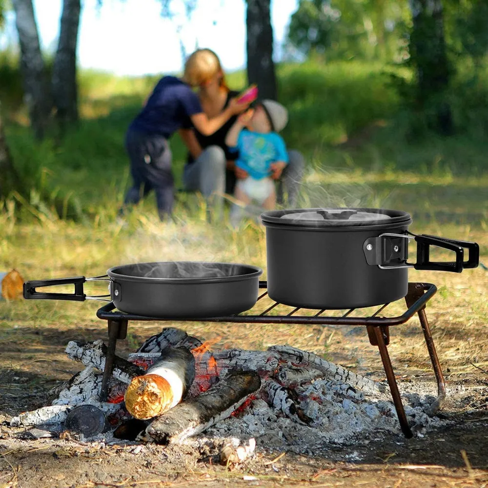 Camp cookware steaming on a grill over a campfire